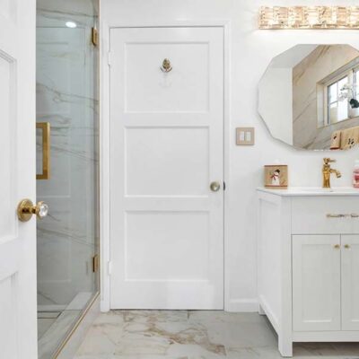 A French-style bathroom with a marble floor and white furniture