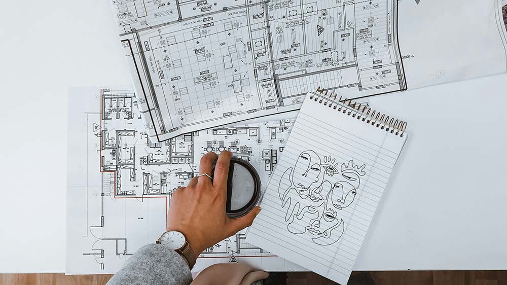 Coffee cup on a stack of home interior design diagrams
