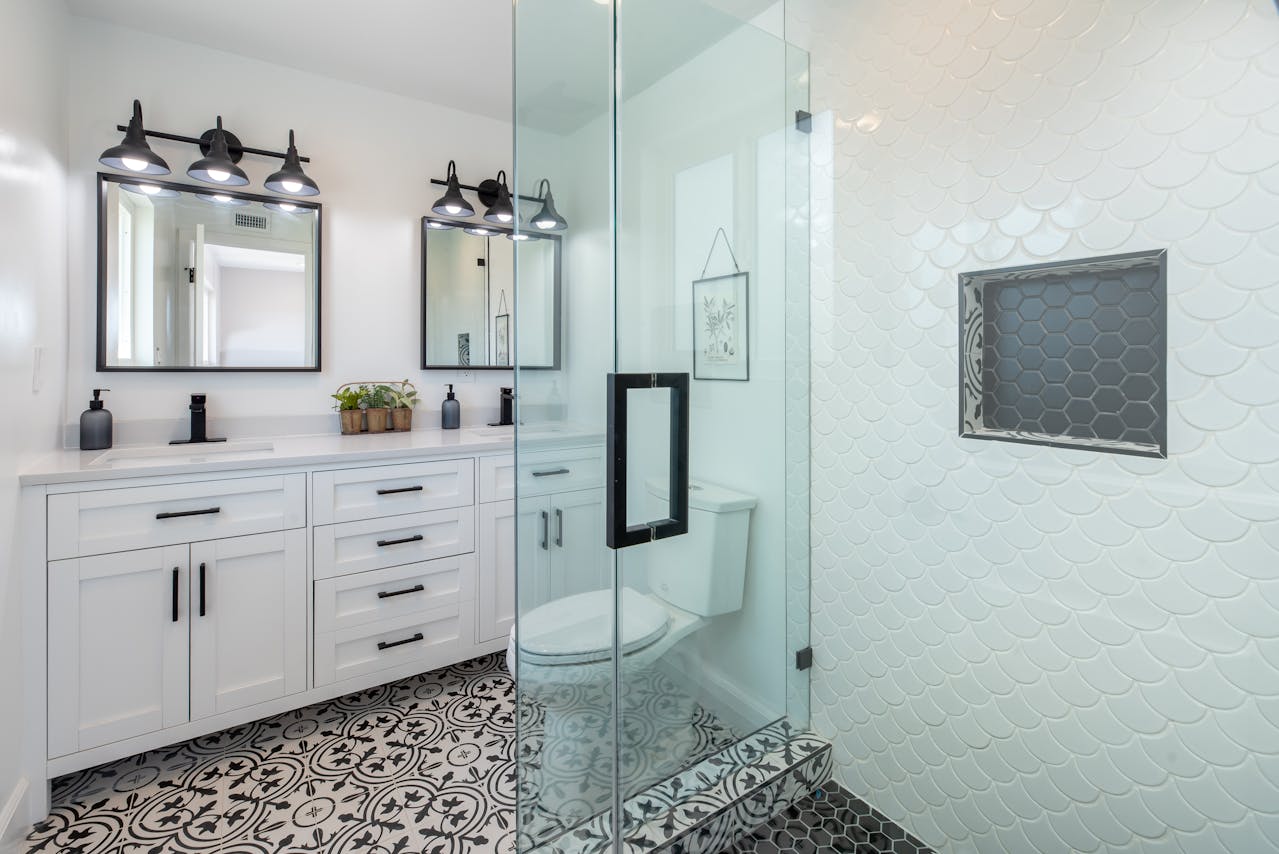 Modern bathroom interior with glass shower and patterned tile flooring