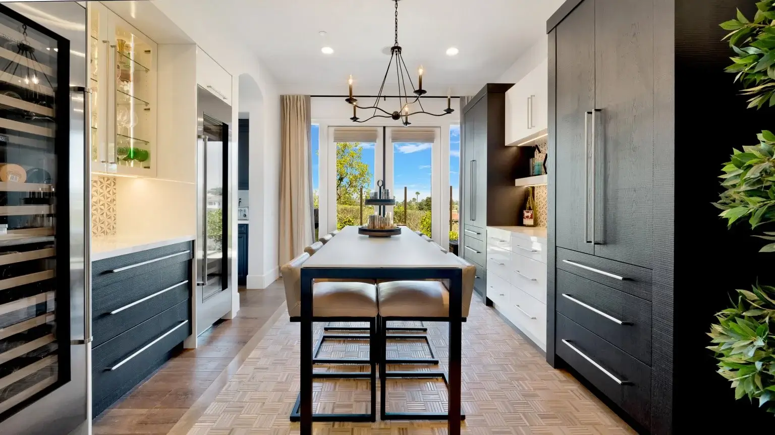 Modern kitchen with sleek black cabinetry and large dining table
