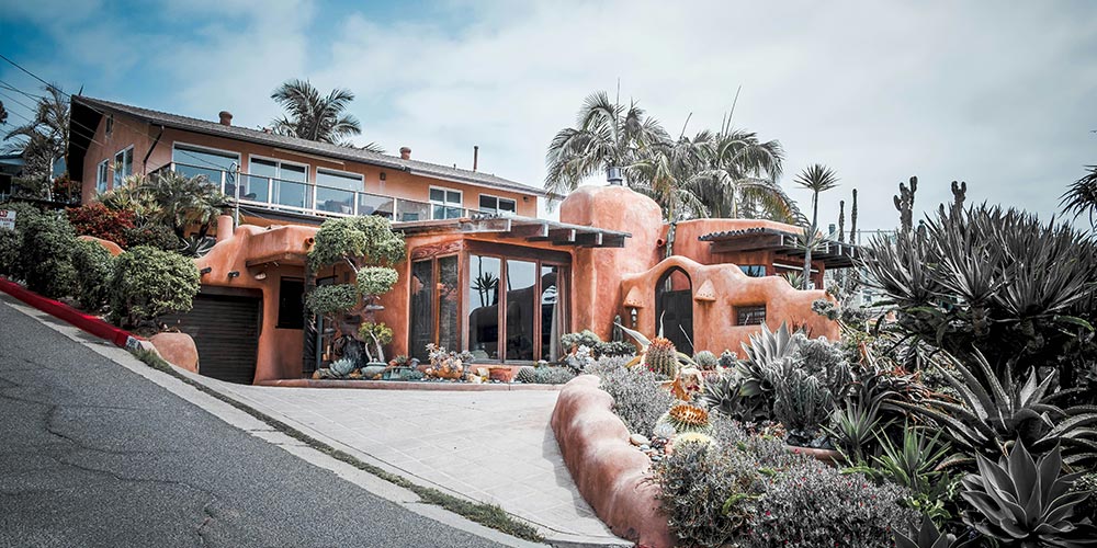 A multi-level house with orange walls situated on a sloped driveway