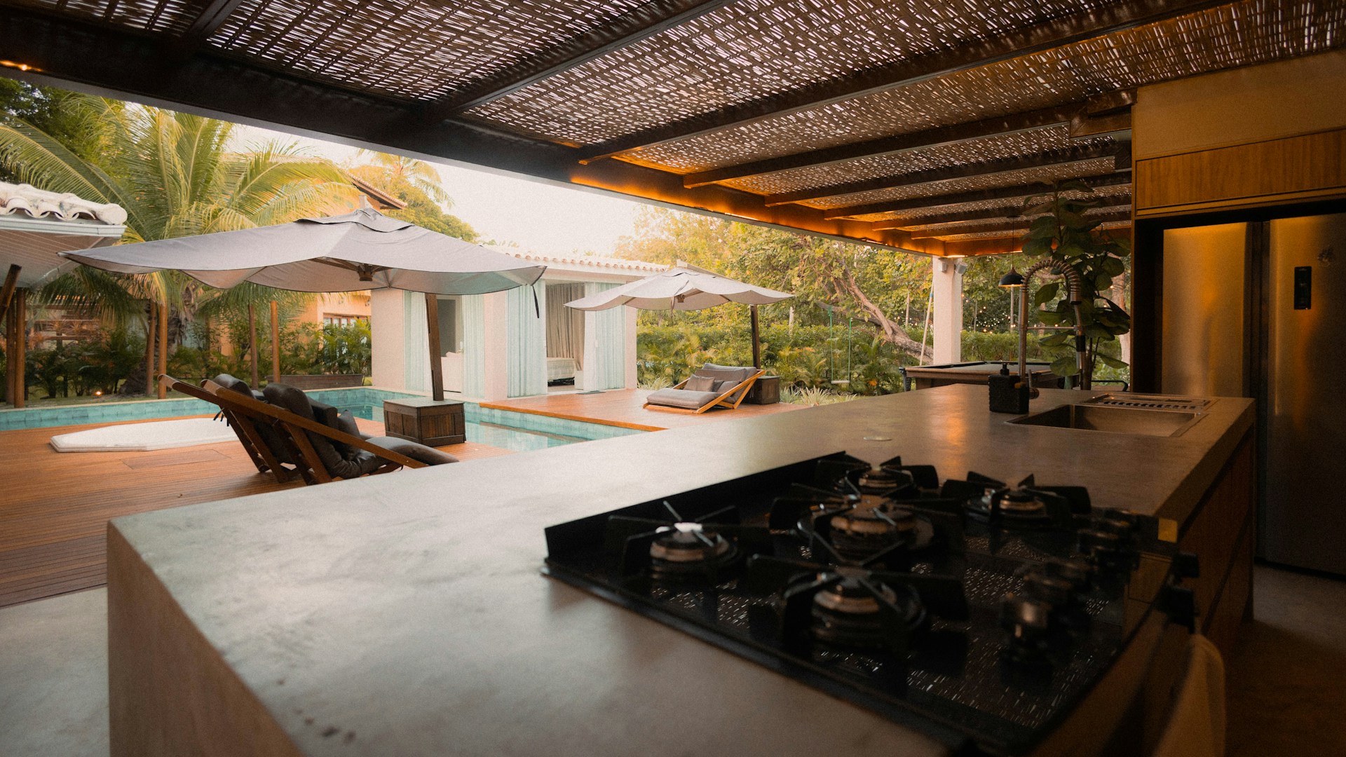 Shaded outdoor kitchen next to a pool