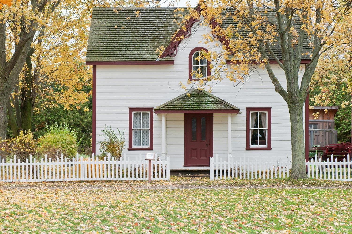 A small house surrounded by a white picket fence