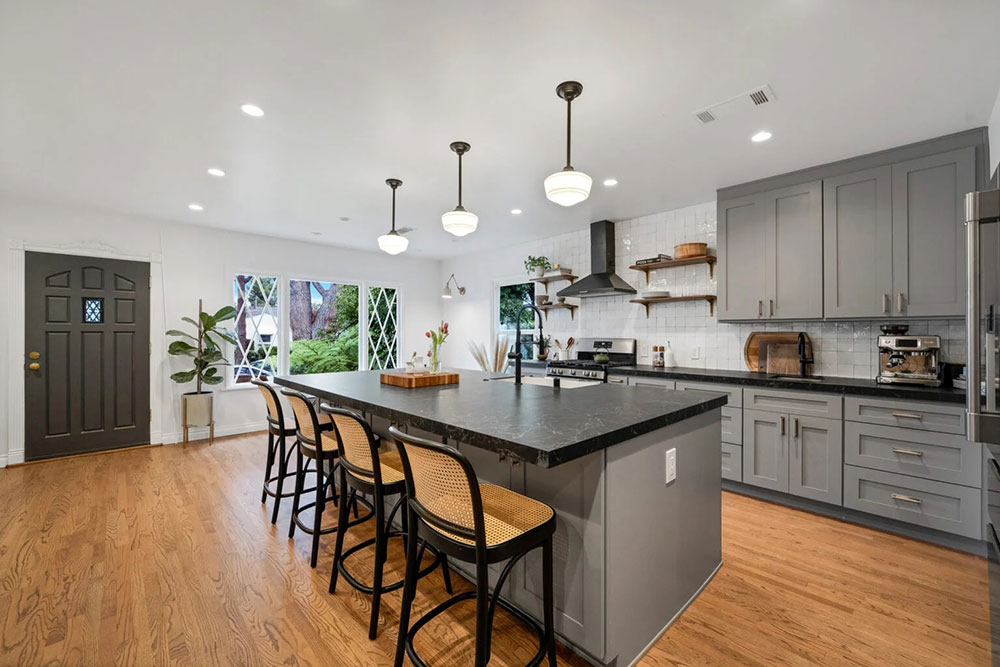 Transitional kitchen remodel with gray cabinets and black countertops.