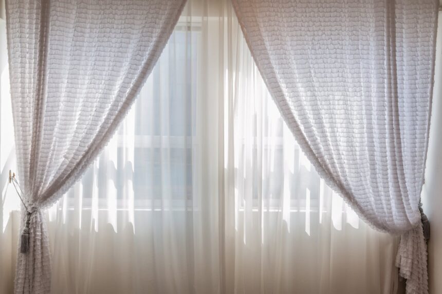 White curtains and white sheers over an interior window